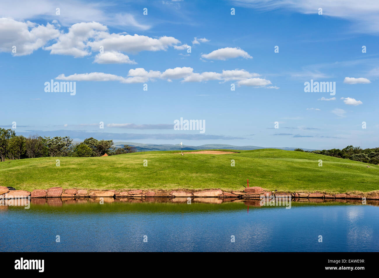 Morning view of a golf fairway and putting green beside a water trap. Stock Photo