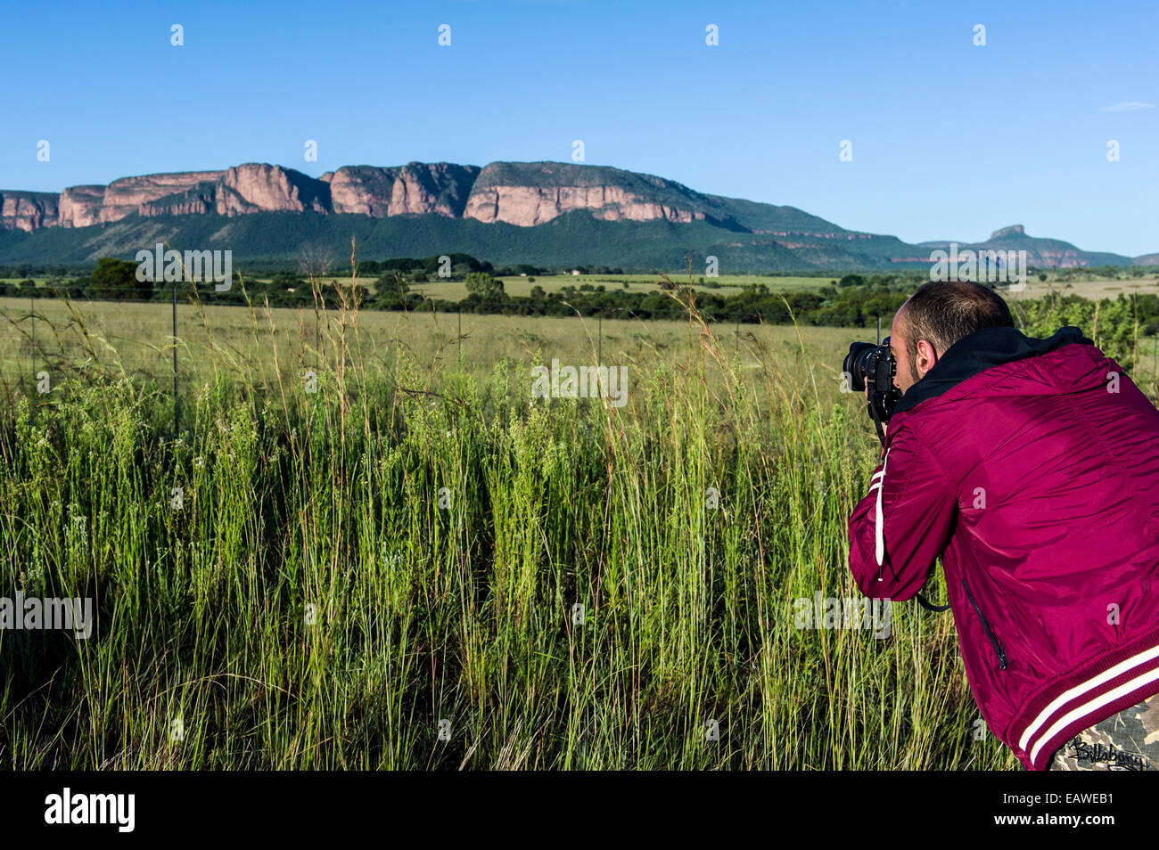 A photographer captures a mountain range on a sunny morning. Stock Photo