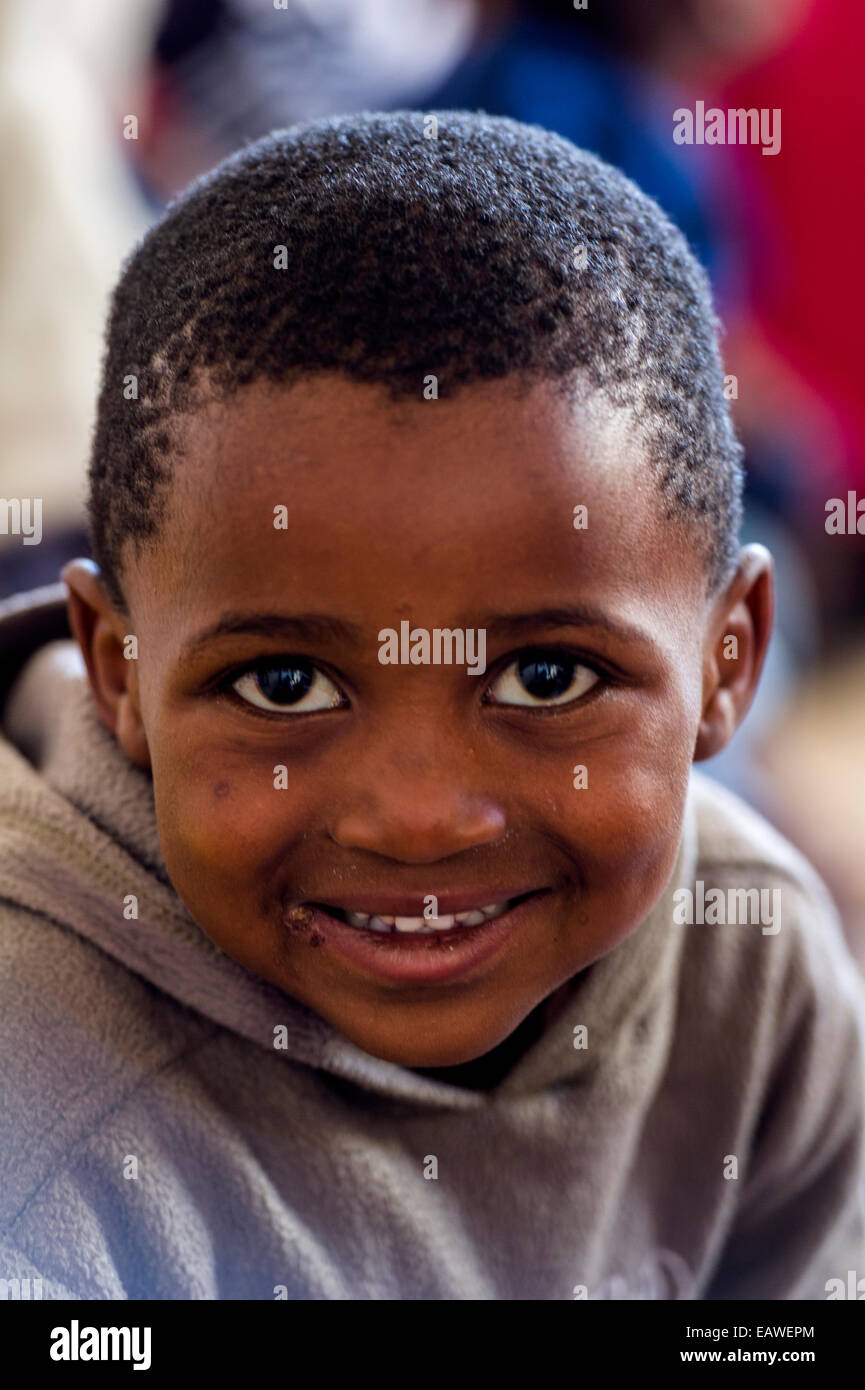 A happy boy enjoys working on the alphabet whilst attending school. Stock Photo