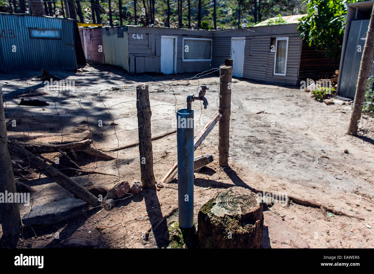 Township homes made of scrap metal and a communal water supply tap. Stock Photo