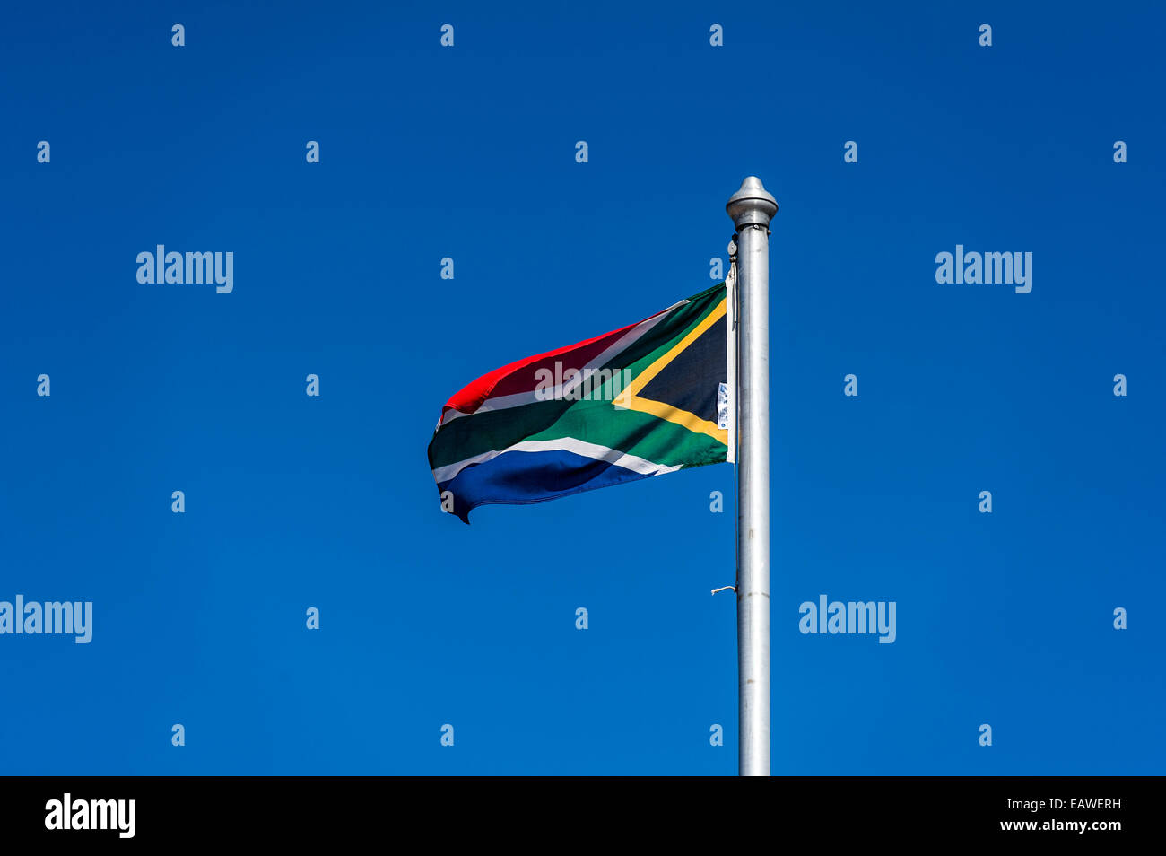The South African flag fluttering in a clear blue sky above a prison. Stock Photo