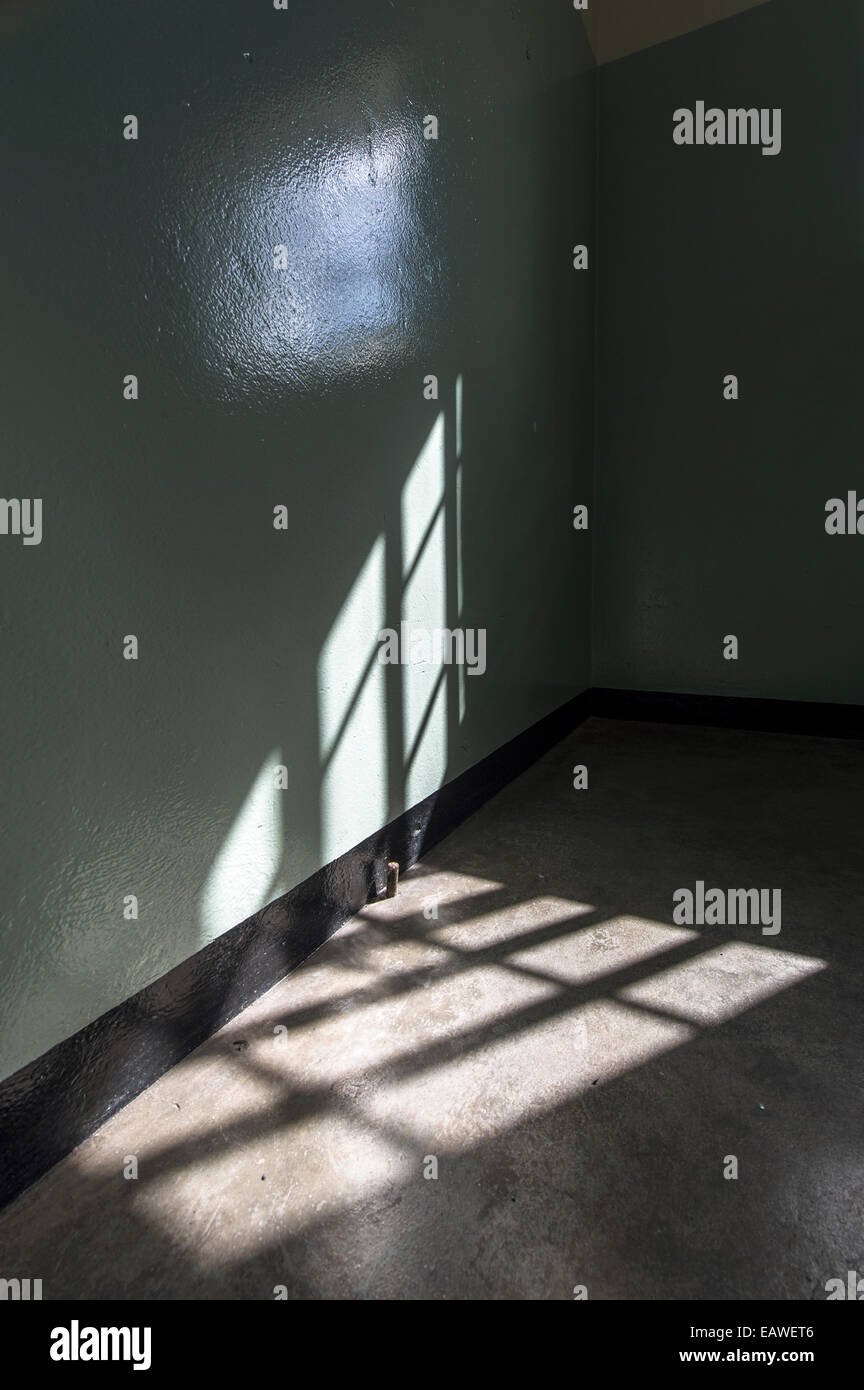 Sun rays cast window bar shadows into Nelson Mandela's prison cell. Stock Photo