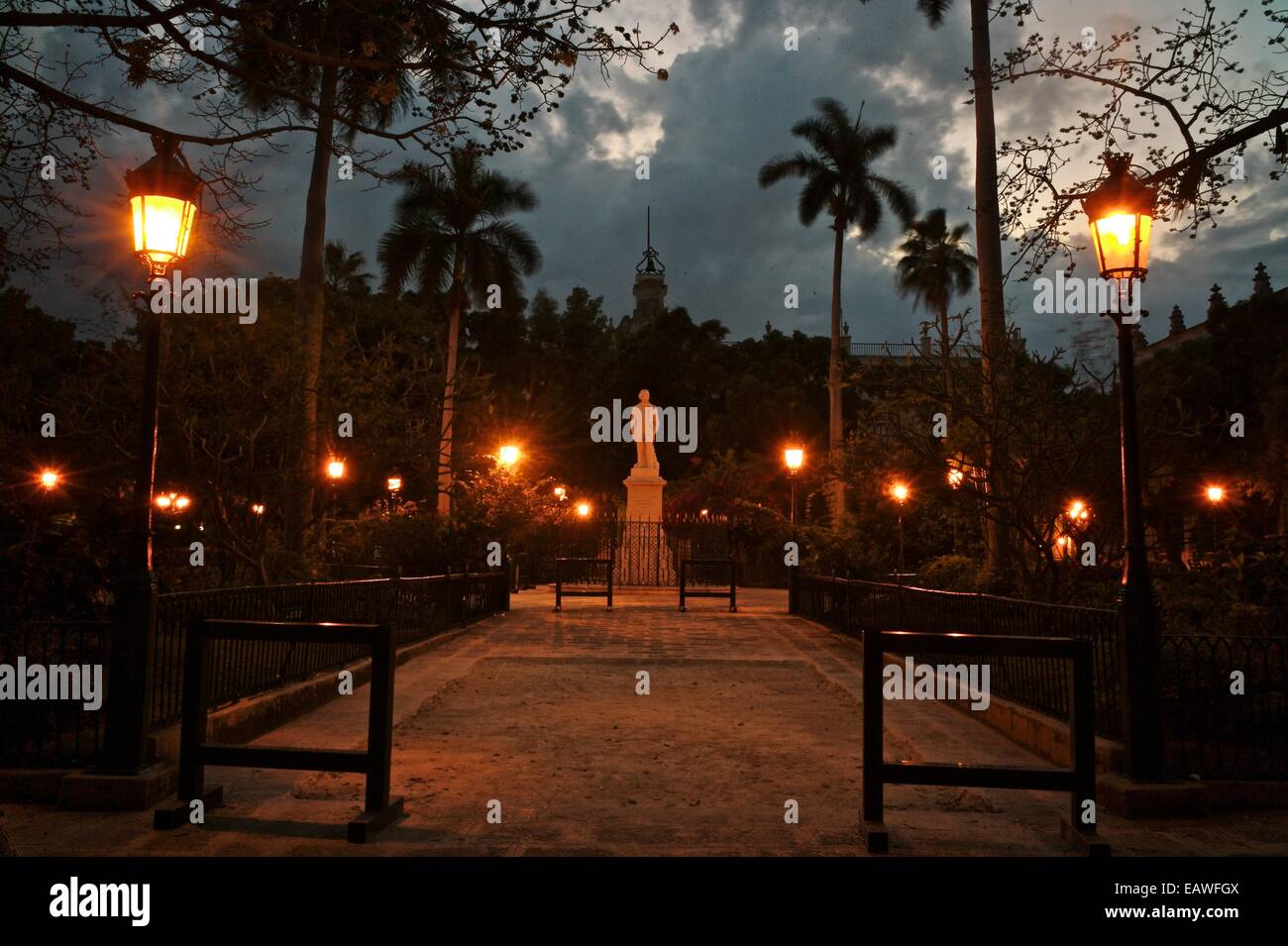 Street lights illuminate a statue in Havana's Plaza de Armas Stock