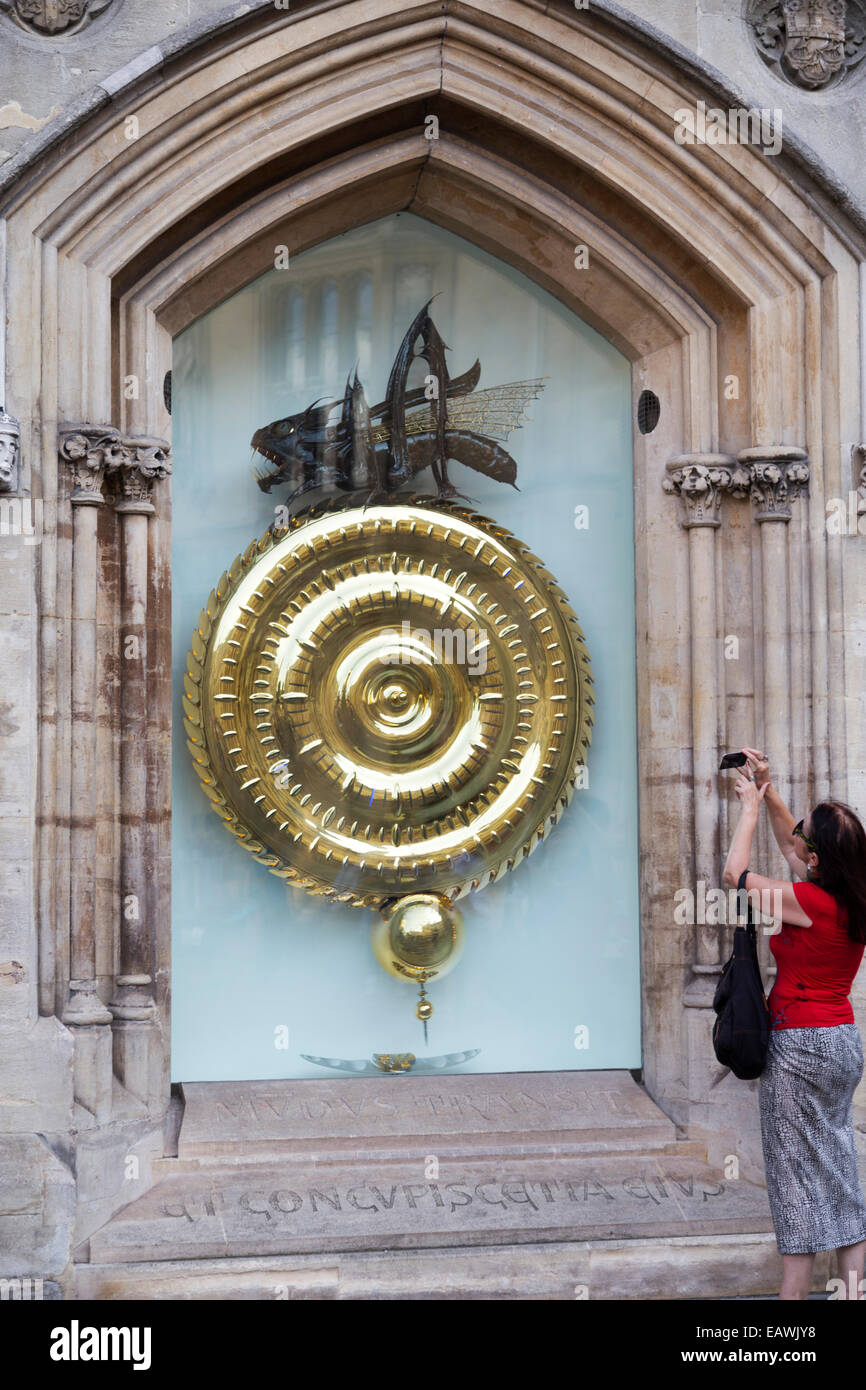UK, Cambridge, tourist taking photograph of the 24 carat gold Corpus Christy College clock. Stock Photo