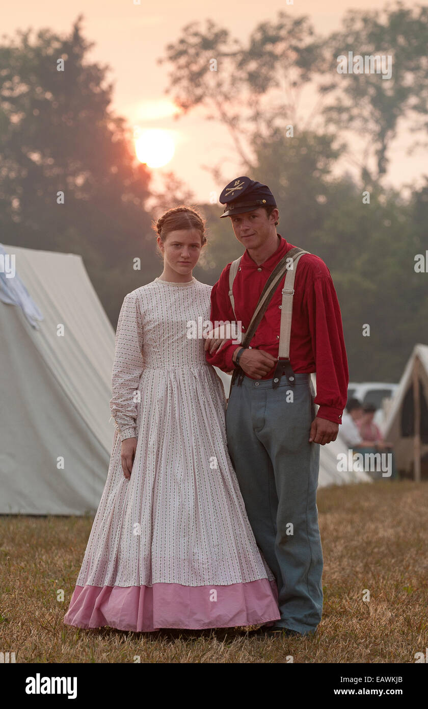 A young couple dressed in Civil War attire stand arm in arm Stock Photo