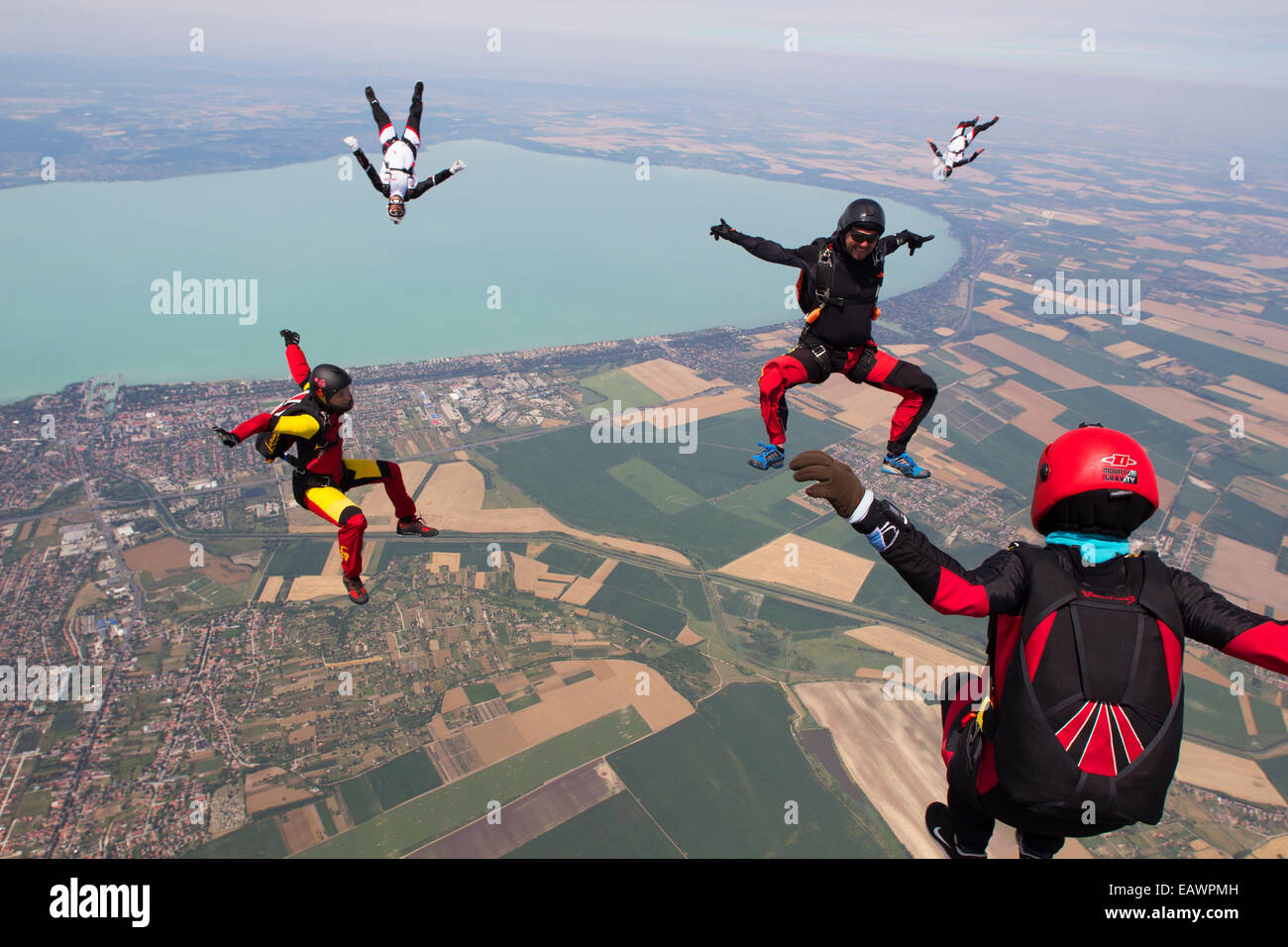 Freefly skydivers are over a spectacular land and fields scenery in the sky with 130 MPH. Stock Photo