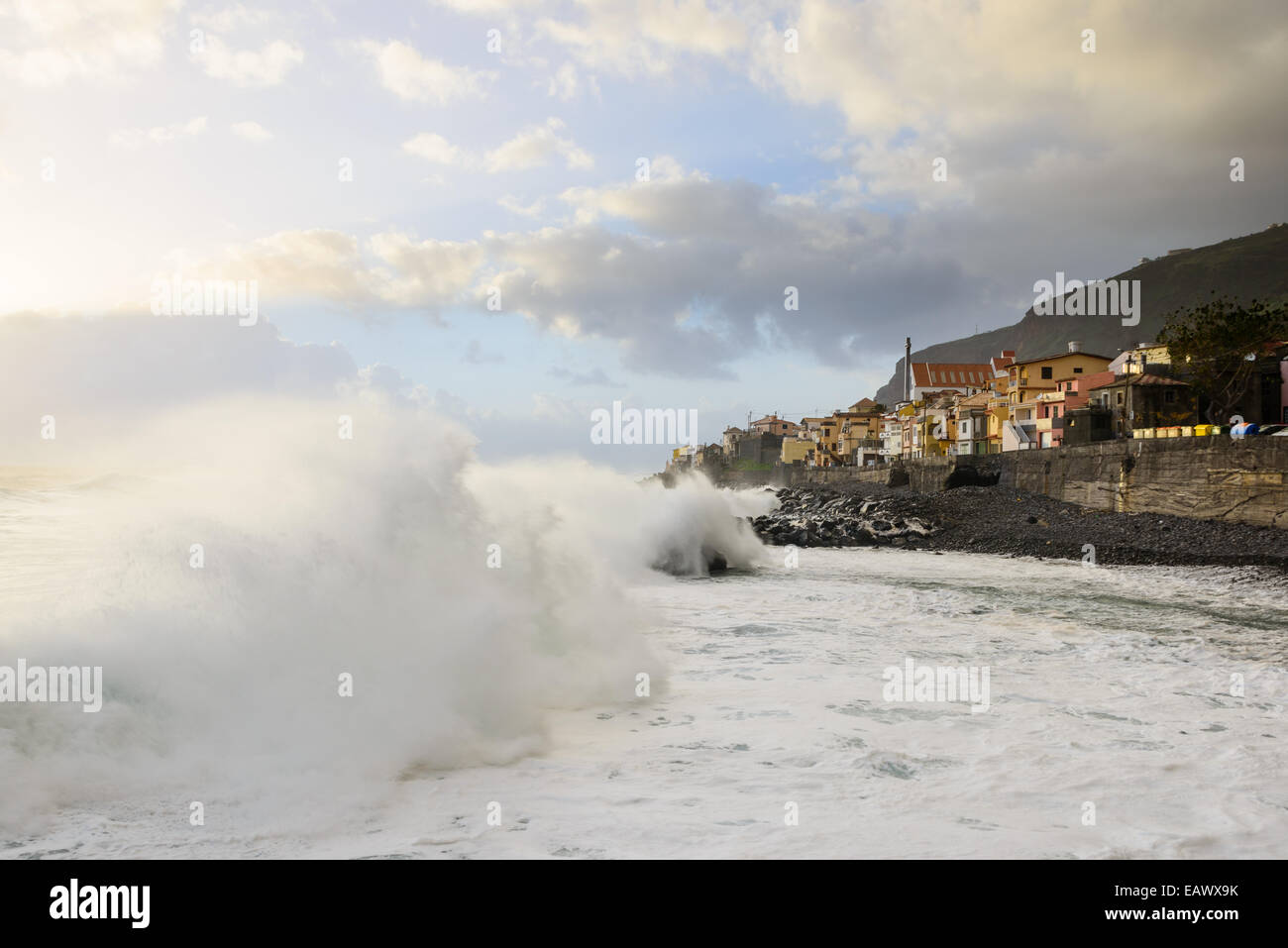 Large foamy wave crashing onto shore Stock Photo