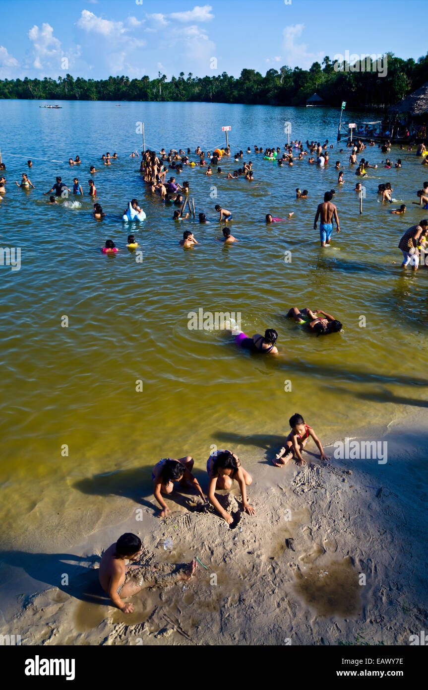 Families and children from an Amazonian river town bathing in a lake on a hot weekend afternoon. Stock Photo