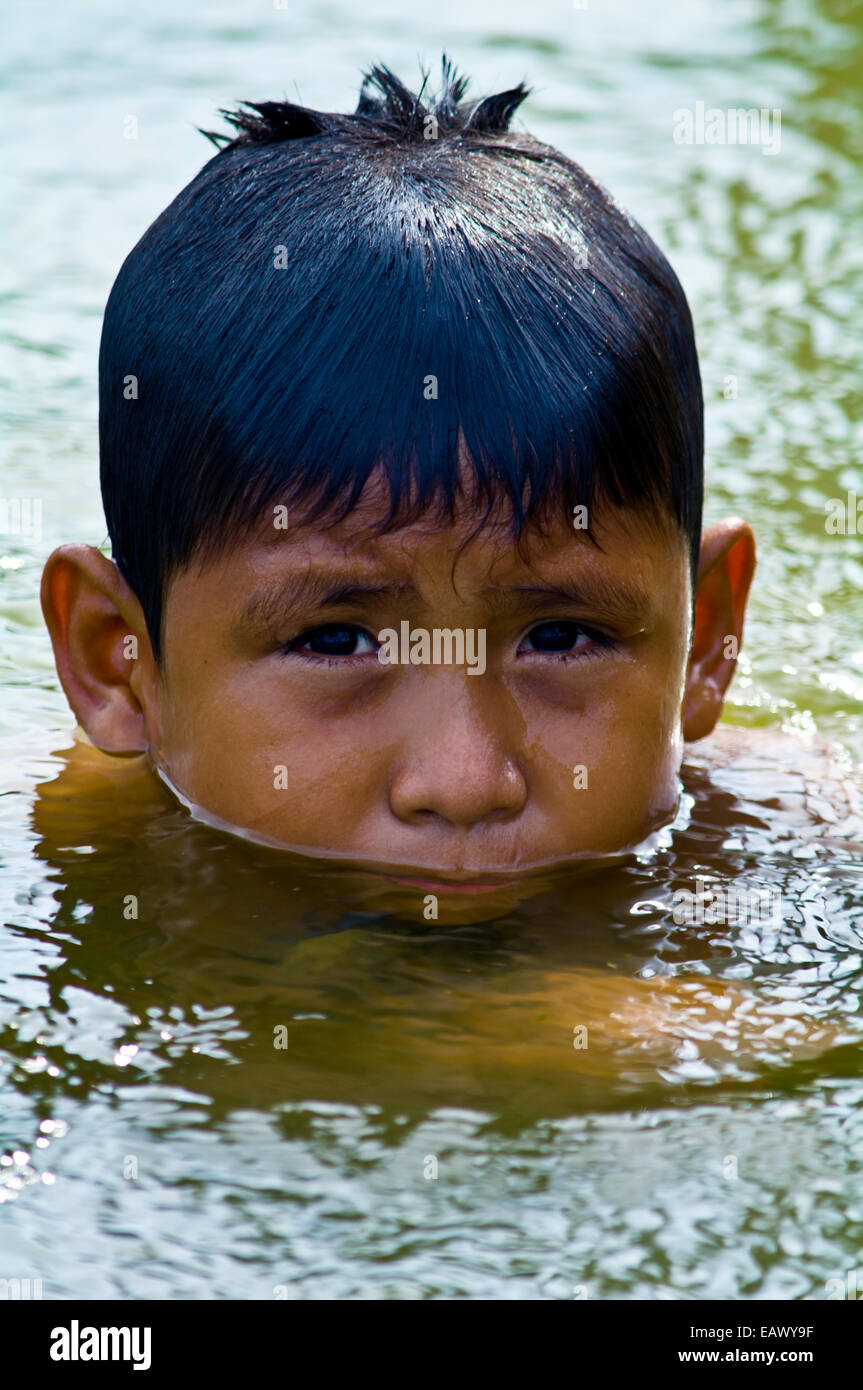 A boy from an Amazonian river town swimming in a lake on a hot weekend ...