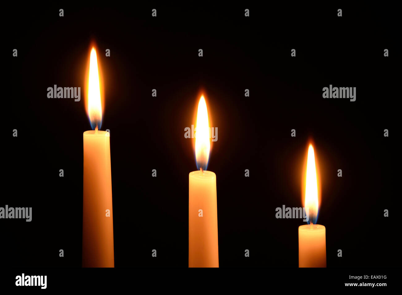 Three white candles on a black background Stock Photo - Alamy