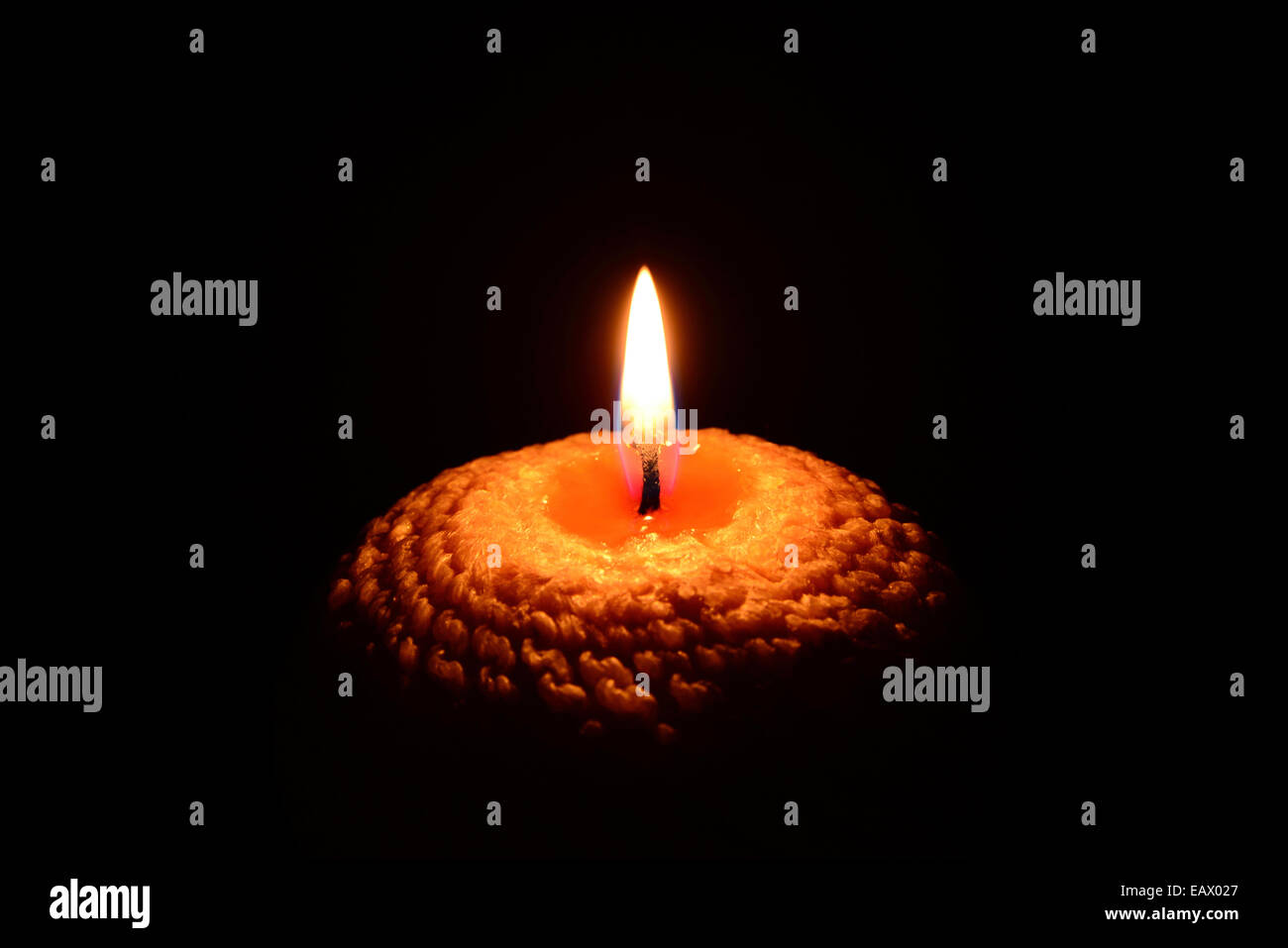 Yellow candle burning on a black background Stock Photo Alamy