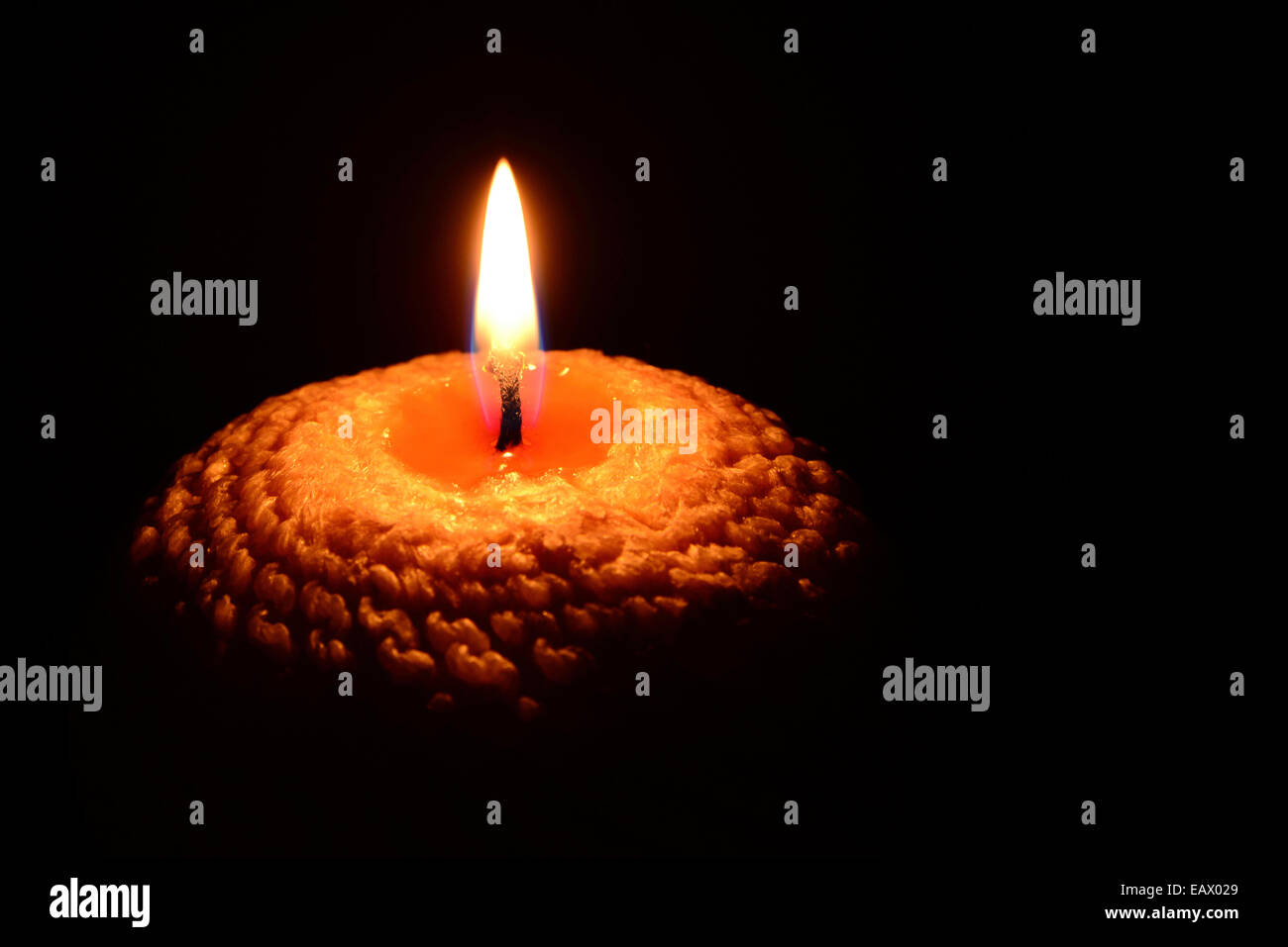 Yellow candle burning on a black background Stock Photo Alamy