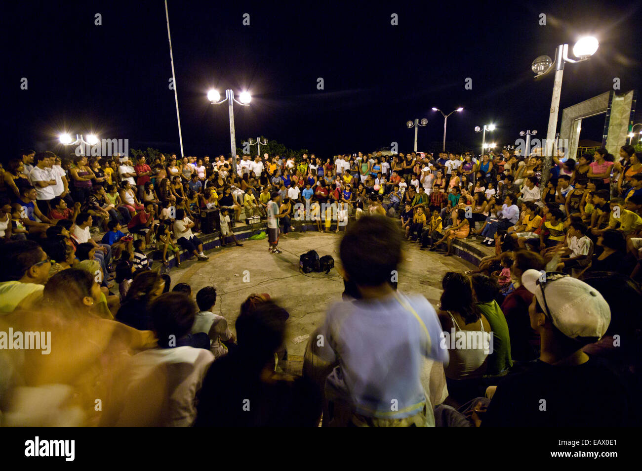 A crowd of onlookers is entertained by comedians at an open-air theatre in an Amazon river town. Stock Photo