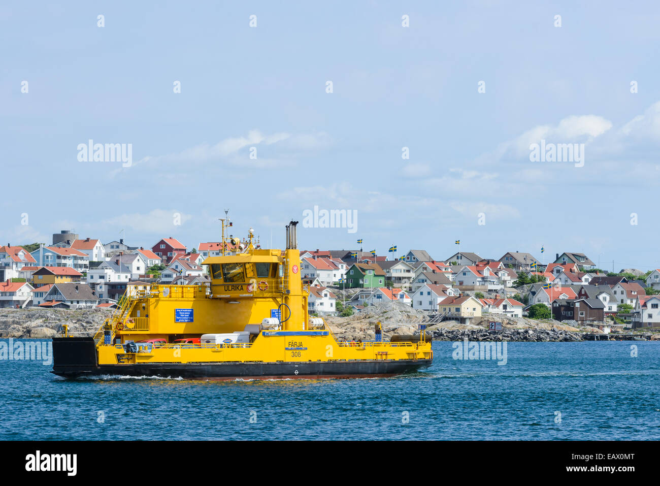 Car ferry passing by houses on the shore Stock Photo
