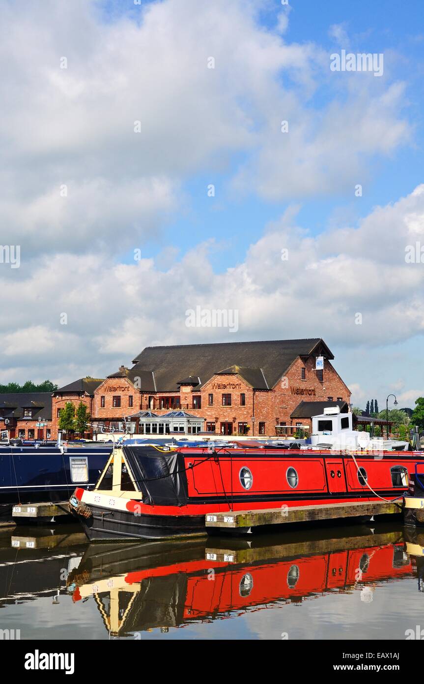 Narrowboats on their moorings in the canal basin with shops, bars and