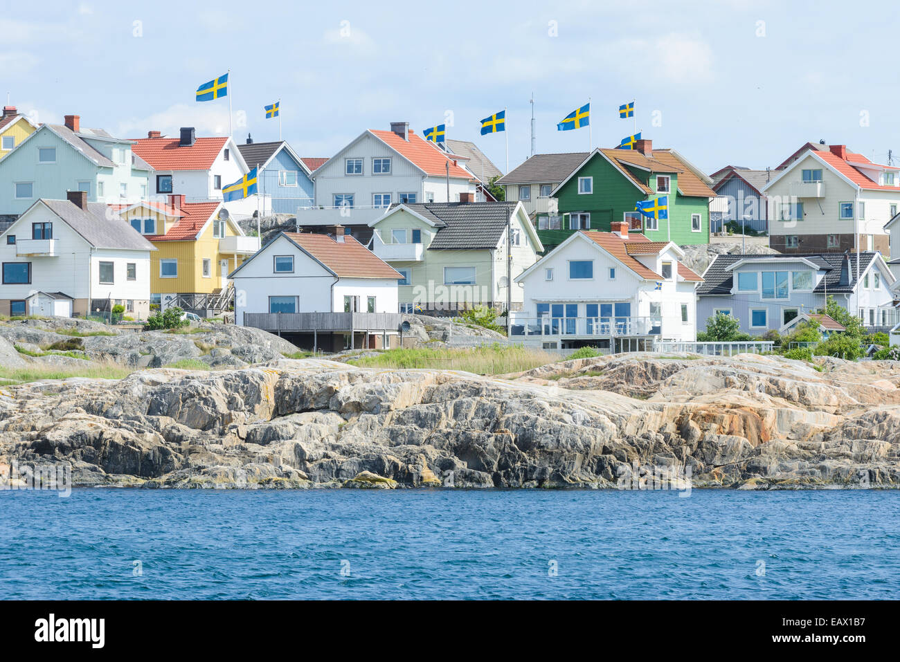 Houses along the shore bearing Swedish flags Stock Photo