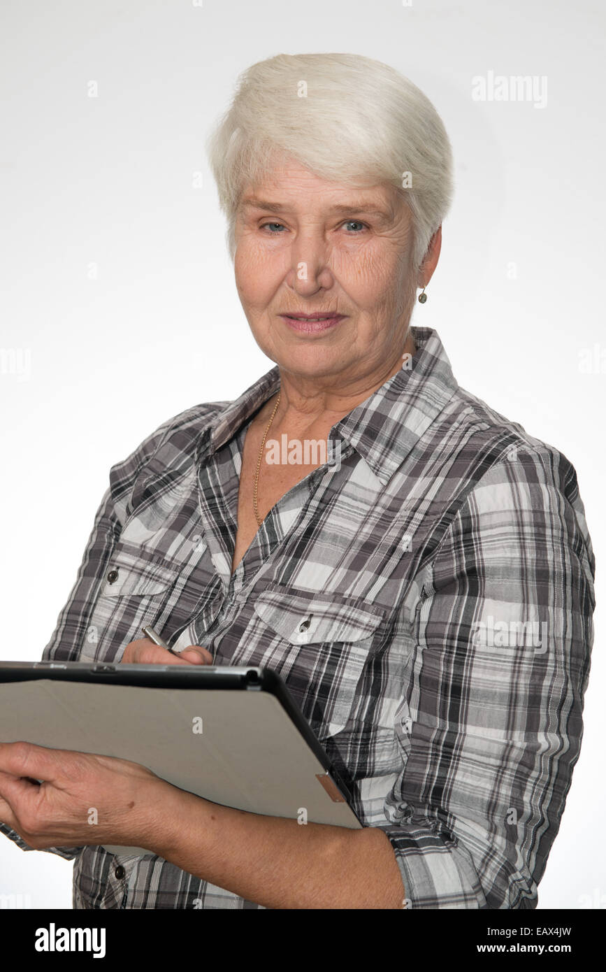 elderly woman works with tablet pc, white background Stock Photo