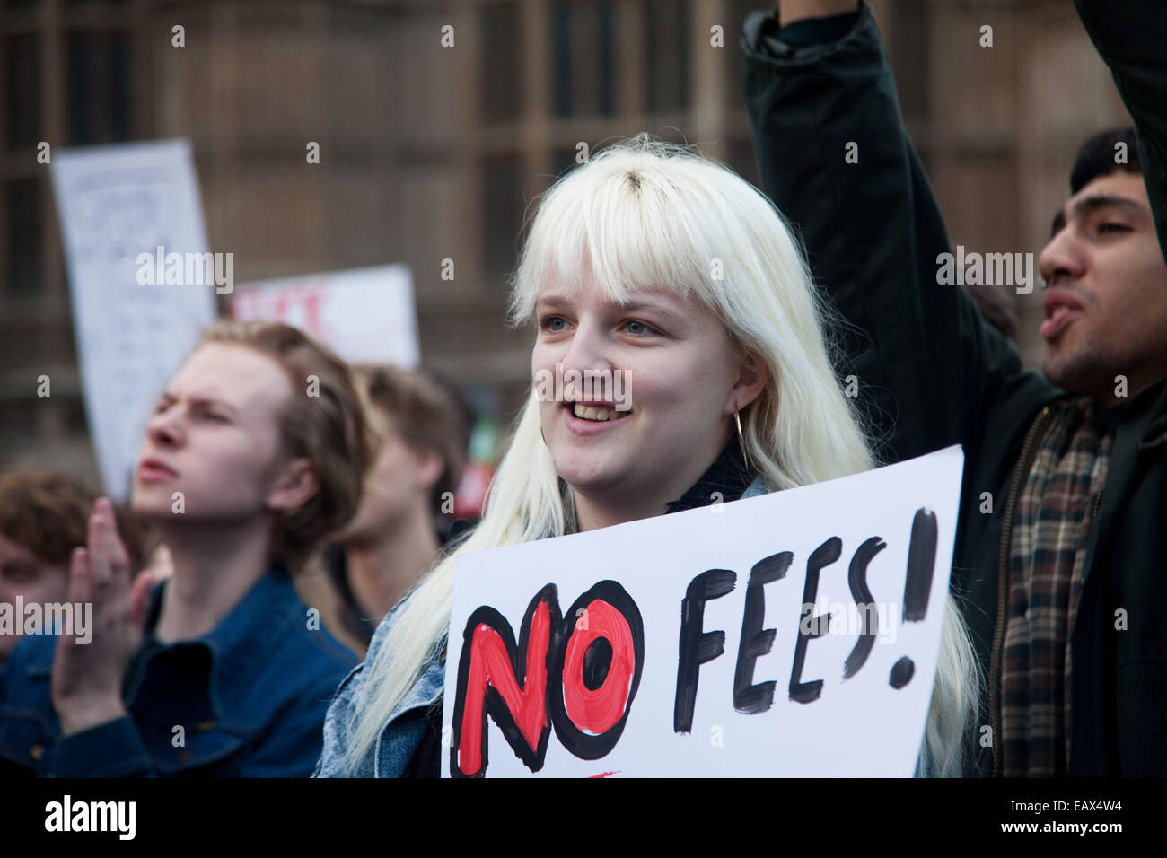A young woman with a placard calling for No Fee cheers the speaker at the rally, Caroline Lucas MP. Stock Photo