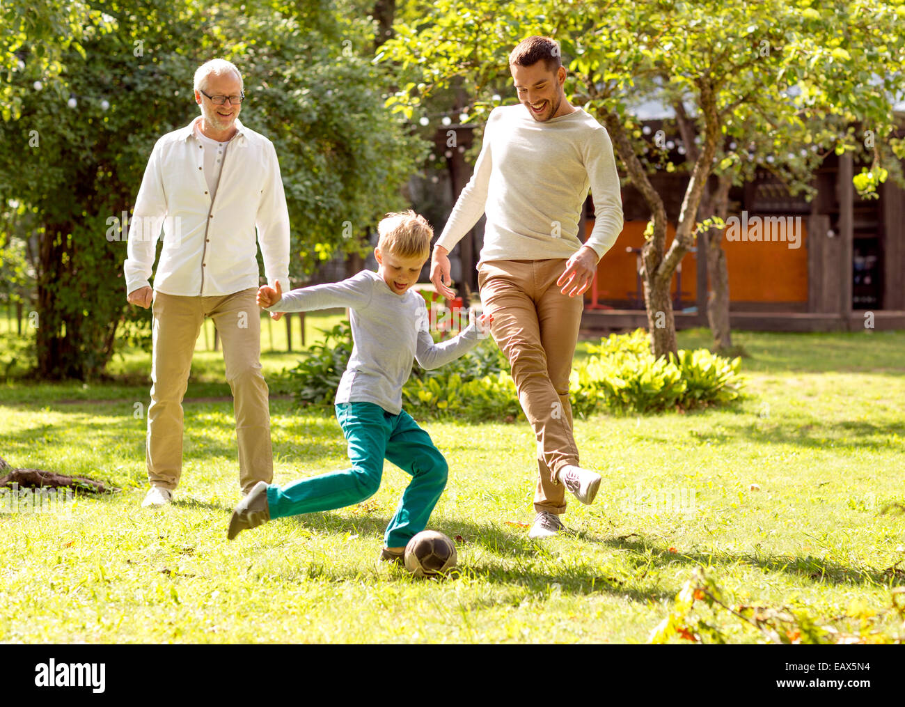 happy family playing football outdoors Stock Photo