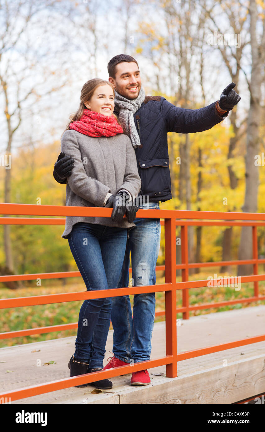 smiling couple hugging on bridge in autumn park Stock Photo - Alamy