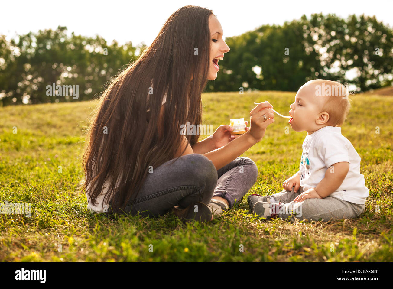She feed. Женщина сидит на бутылке при детях. She feed. Ребенка кормят на природе родители. Мама кормит сына с ложки.