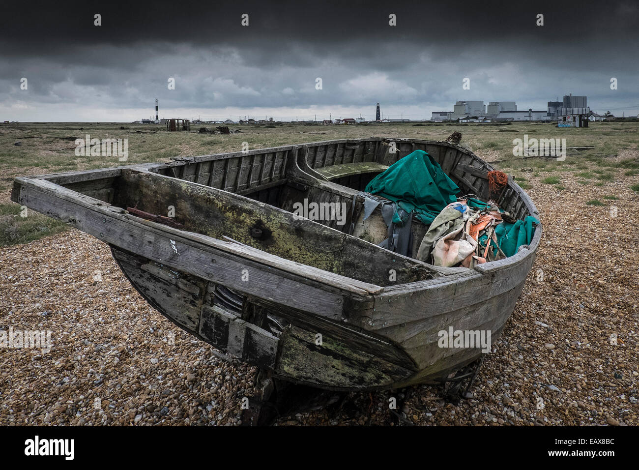 An old wooden fishing boat abandoned on the beach at Dungeness in Kent ...