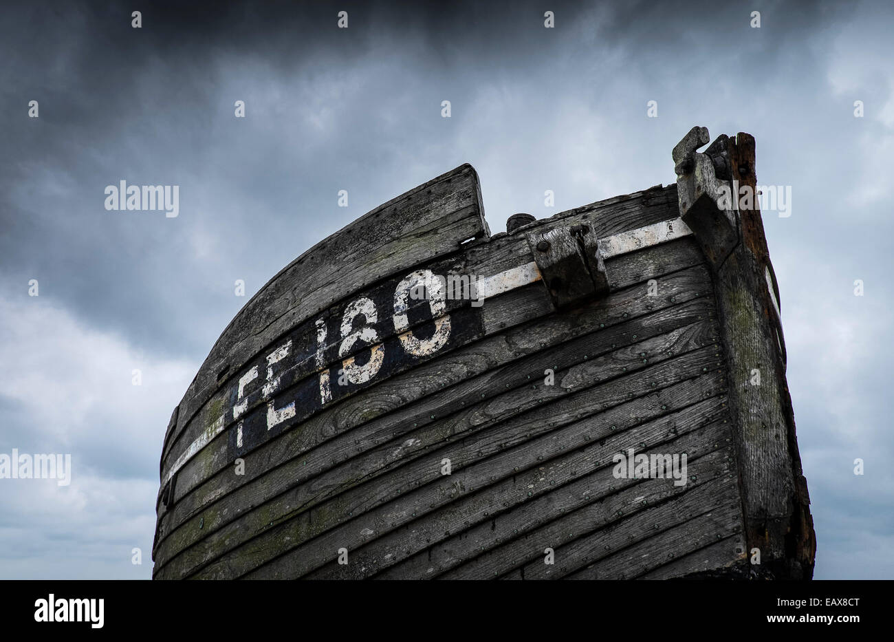 An abandoned wooden fishing boat on the beach at Dungeness in Kent ...