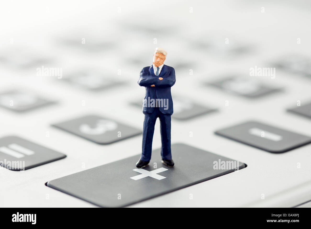 Businessman figurine standing on calculator Stock Photo