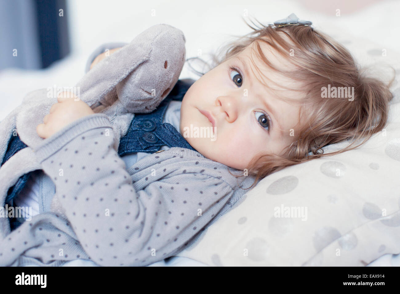 Baby girl lying down with stuffed toy, portrait Stock Photo