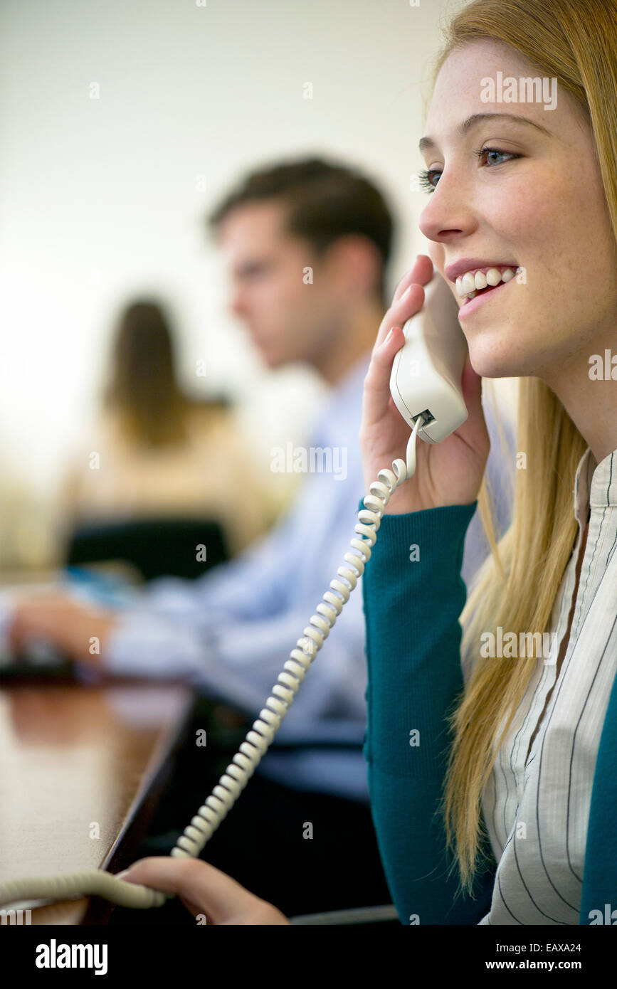 Woman using landline phone in office Stock Photo Alamy