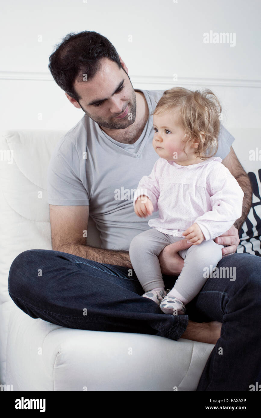 Father holding baby girl on lap Stock Photo