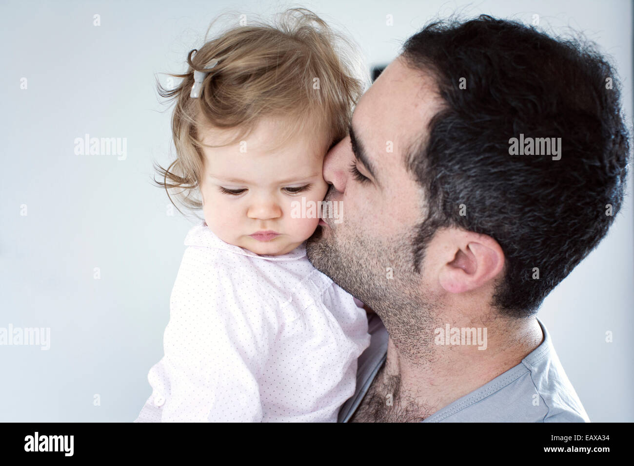 Father kissing baby girl's cheek Stock Photo