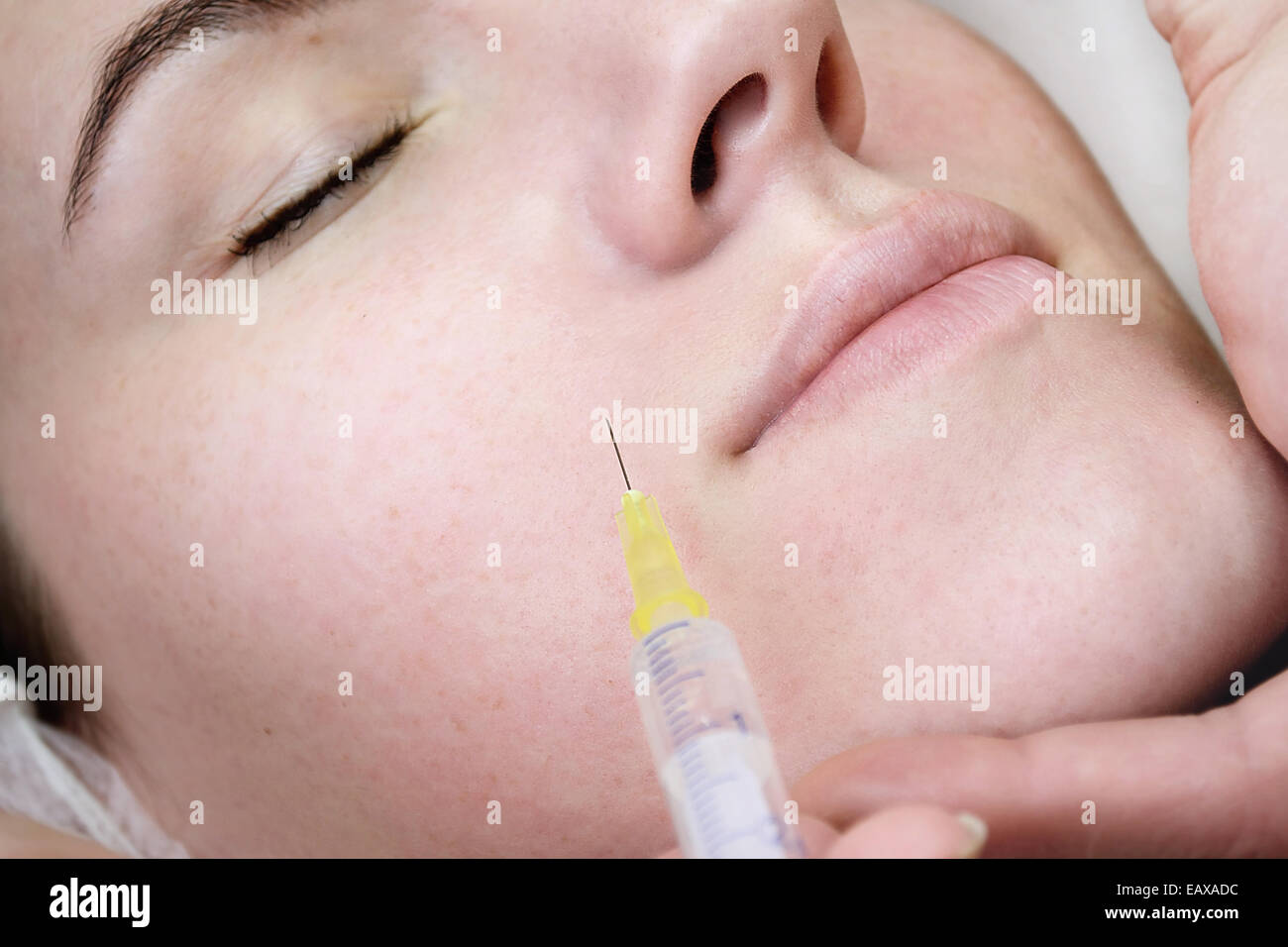Beautiful woman gets an injection in her face in spa salon Stock Photo
