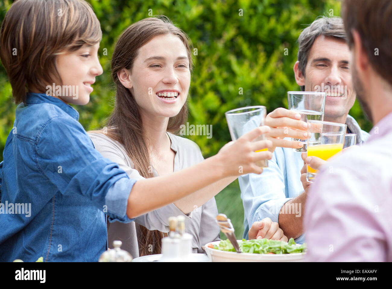 Family clinking glasses at outdoor gathering Stock Photo