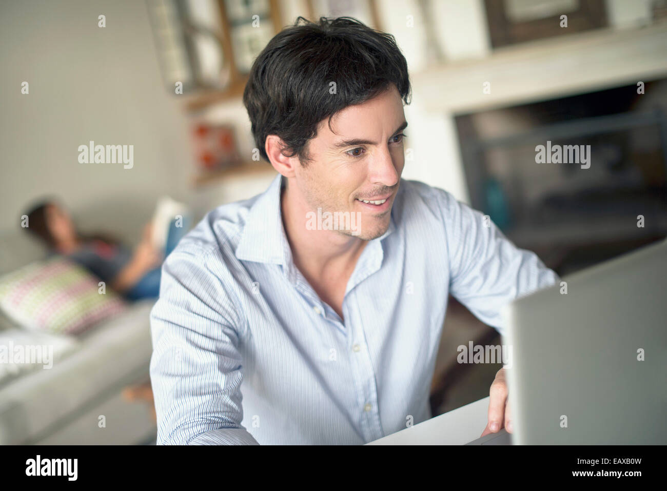 Man using laptop computer in living room Stock Photo - Alamy