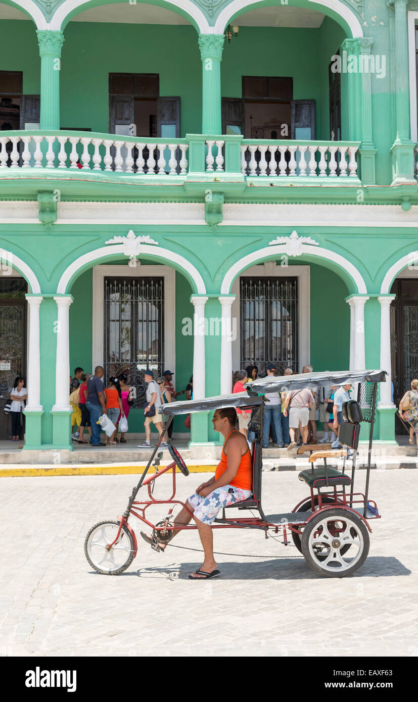 SANTA CLARA, CUBA, MAY 9, 2014. One rickshaw and their driver waiting in the street in Santa Clara, Cuba Stock Photo