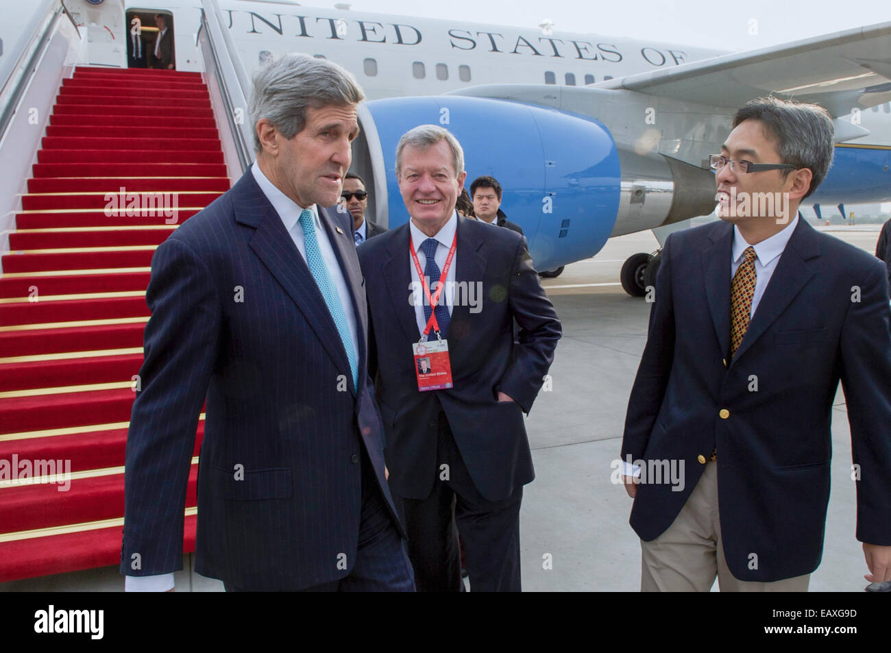 U.S. Secretary of State John Kerry chats with U.S. Ambassador to China Max Baucus and Chinese Ministry of Foreign Affairs official Cai Wei after arriving at Beijing Capital International Airport in Beijing, China on November 7, 2014, for an APEC Ministeri Stock Photo