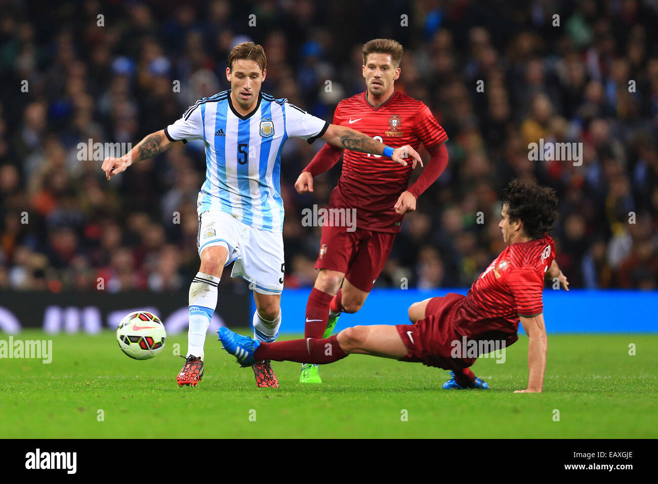 Nov. 18, 2014 - Manchester, United Kingdom - Tiago Mendes of Portugal challenges Lucas Biglia of Argentina - Argentina vs. Portugal - International Friendly - Old Trafford - Manchester - 18/11/2014 Pic Philip Oldham/Sportimage. Stock Photo