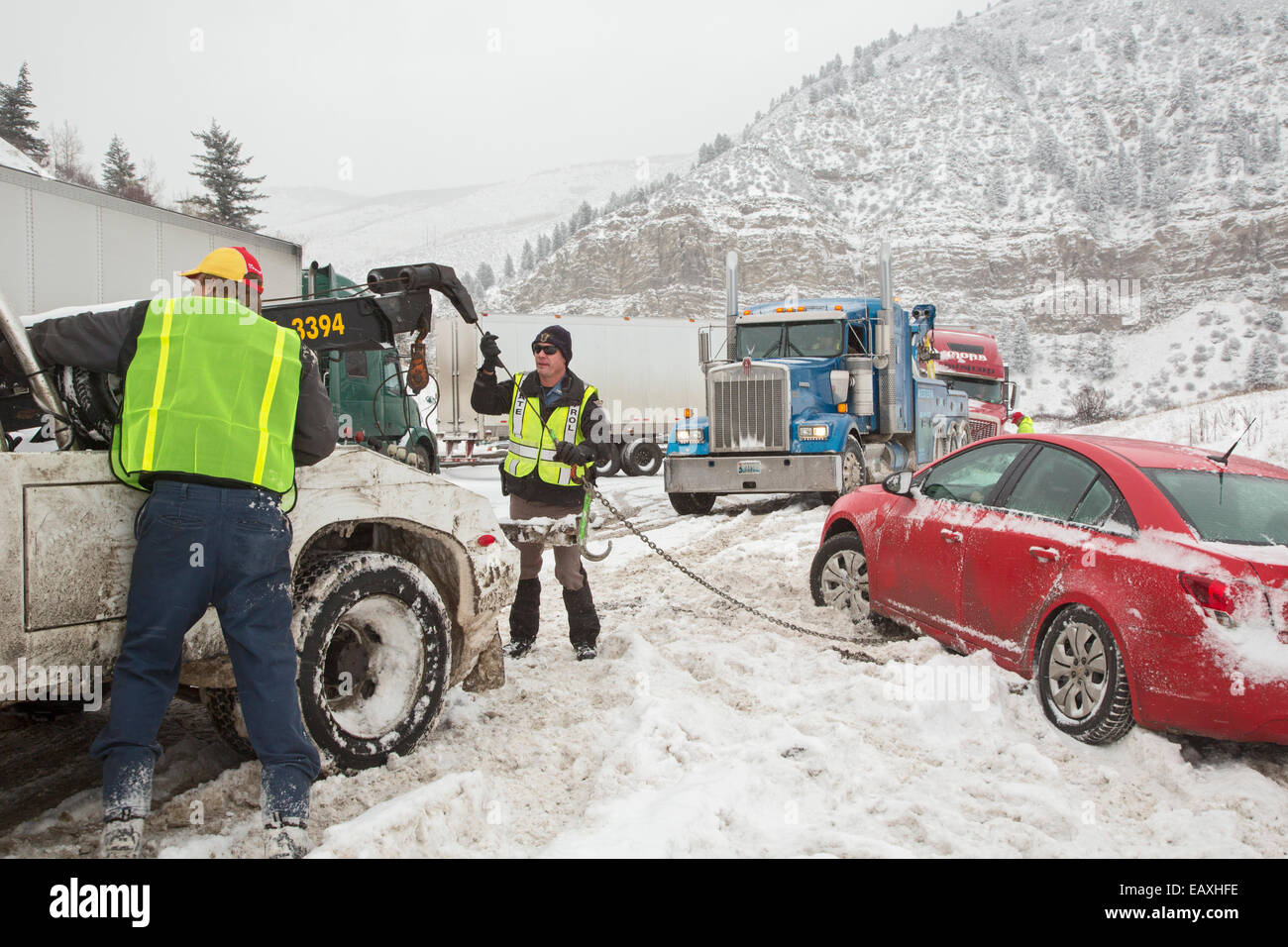 Vail, Colorado - A tow truck operator and a Colorado State Patrol officer prepare to pull a car out of the ditch. Stock Photo