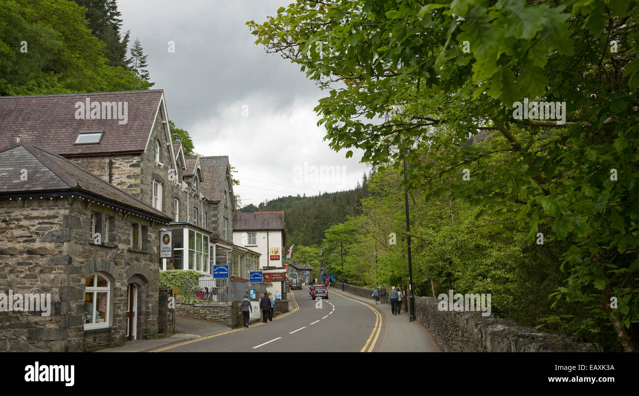 Holyhead Road, main street of  Welsh village of Betws-y-Coed, lined with old stone buildings and emerald woodlands Stock Photo