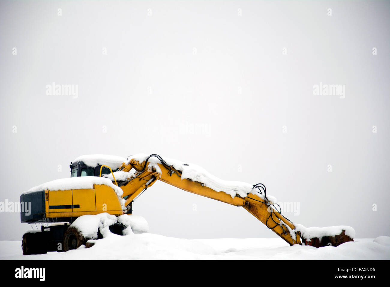 Excavator being covered with a snow in winter. Stock Photo