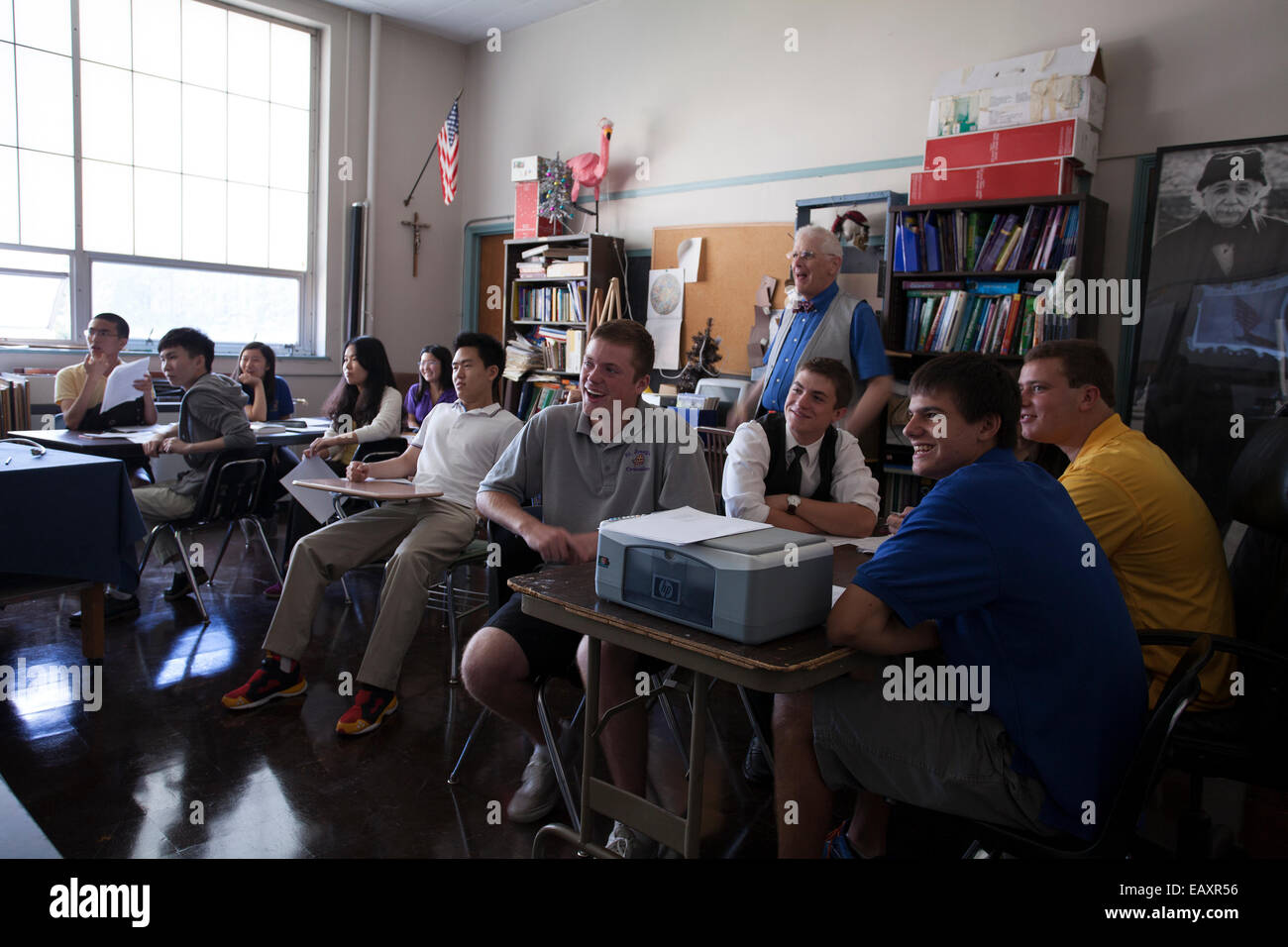 Happy students in a Catholic high school classroom are enjoying their lesson.  Teacher in rear of classroom. Stock Photo