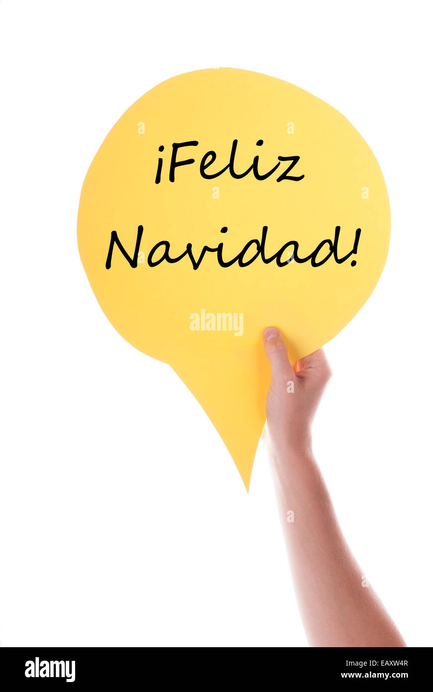 Hand Holding A Yellow Speech Balloon Or Speech Bubble With Spanish Feliz Navidad. Isolated Photo. Stock Photo