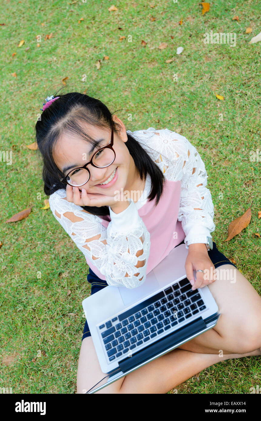 Lovely girl is happy with a laptop on lawn in park Stock Photo - Alamy