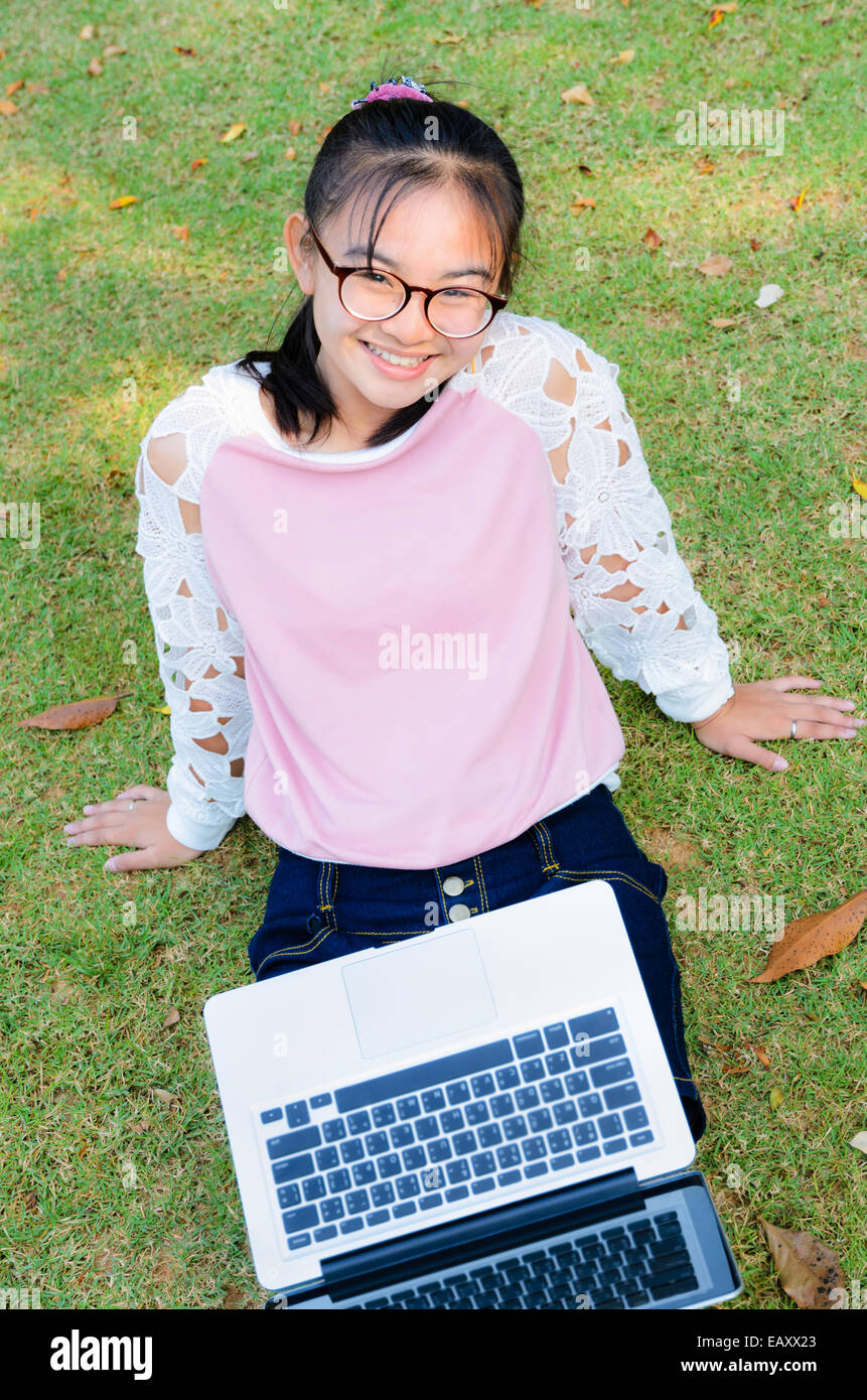 Cute girl is happy with notebook on grass in park Stock Photo - Alamy