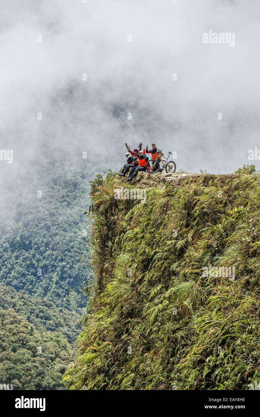 Mountain bikers are posing at a viewpoint of the famous downhill trail 'Road of death' in Bolivia Stock Photo