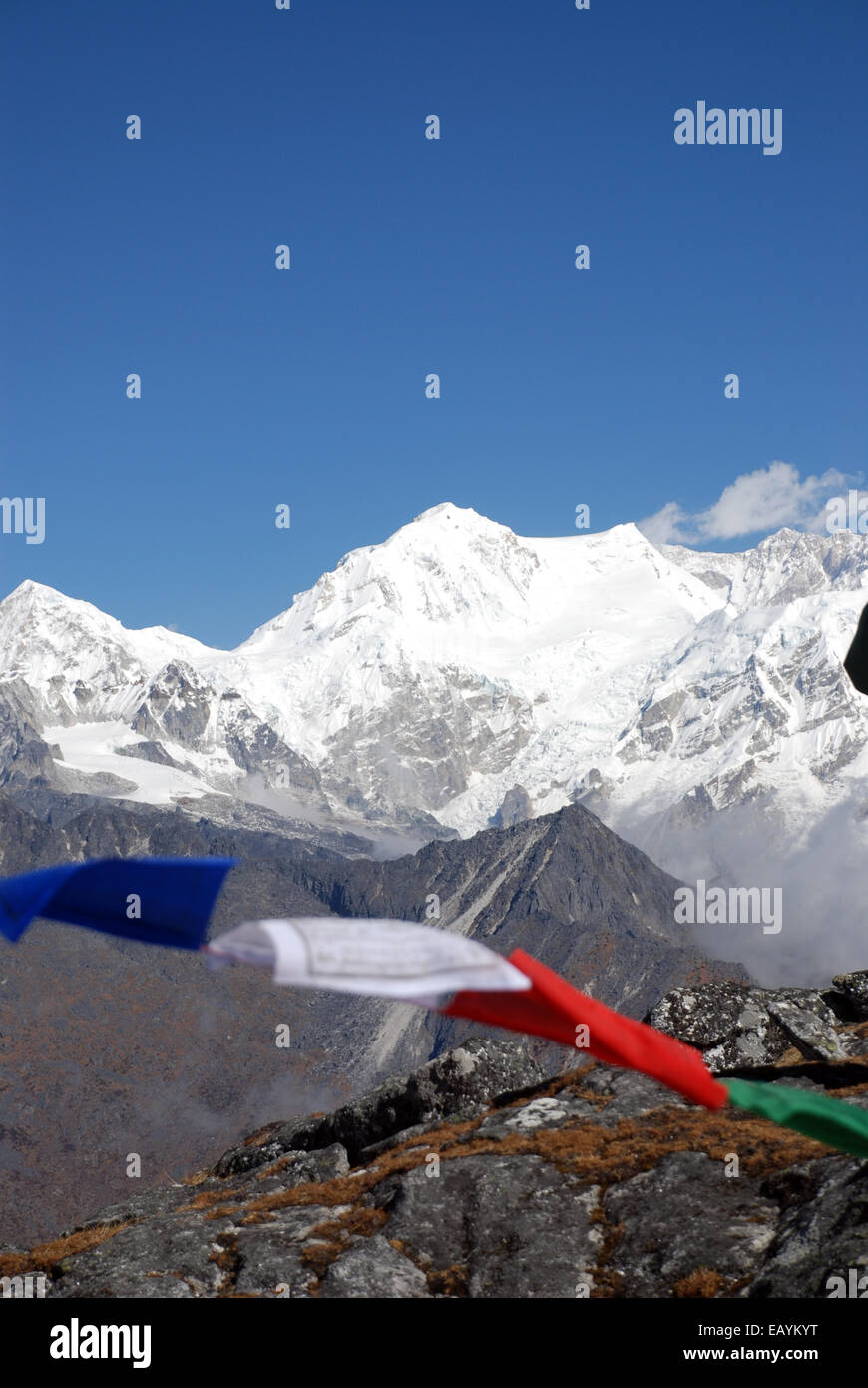 Kanchenjunga with prayer flags in the foreground seen from a high point on the Singalilia ridge in the Indian State of Sikkim Stock Photo