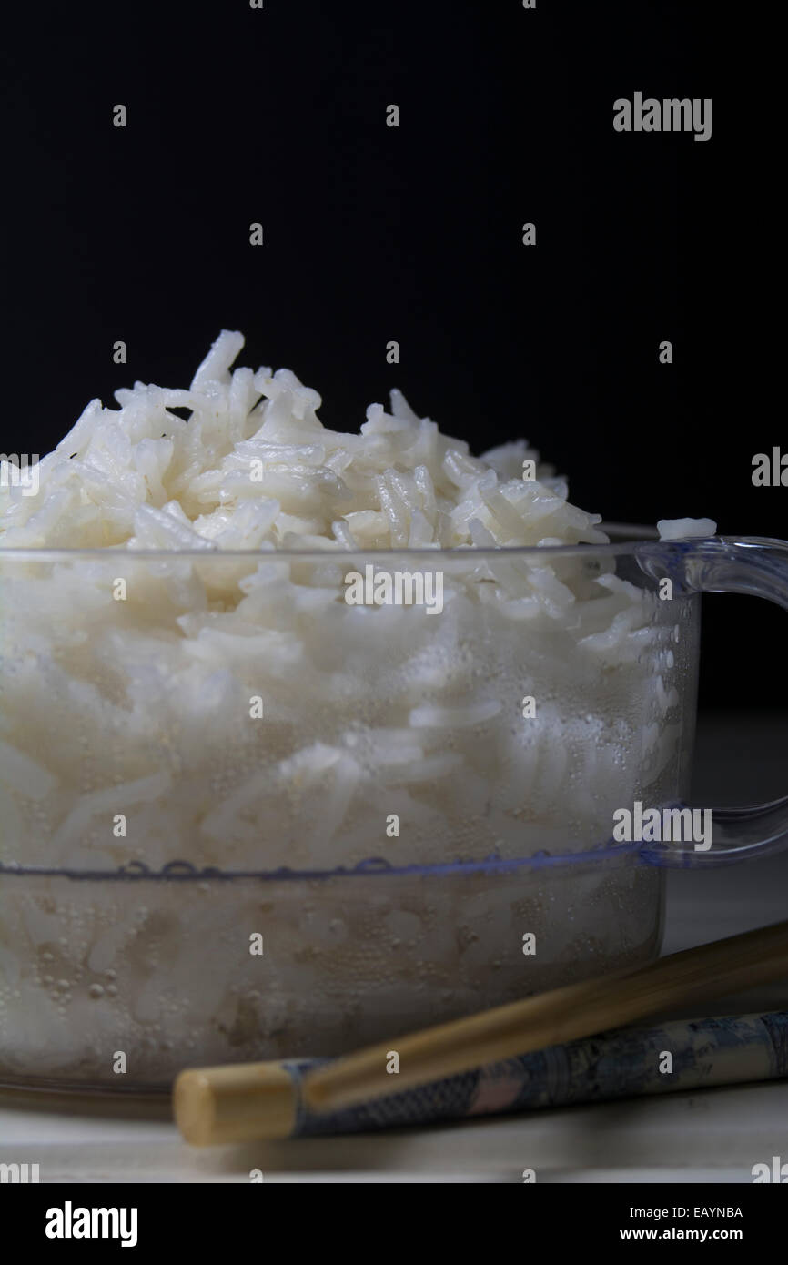 Bowl of white rice, clear container and black chalkboard background Stock Photo