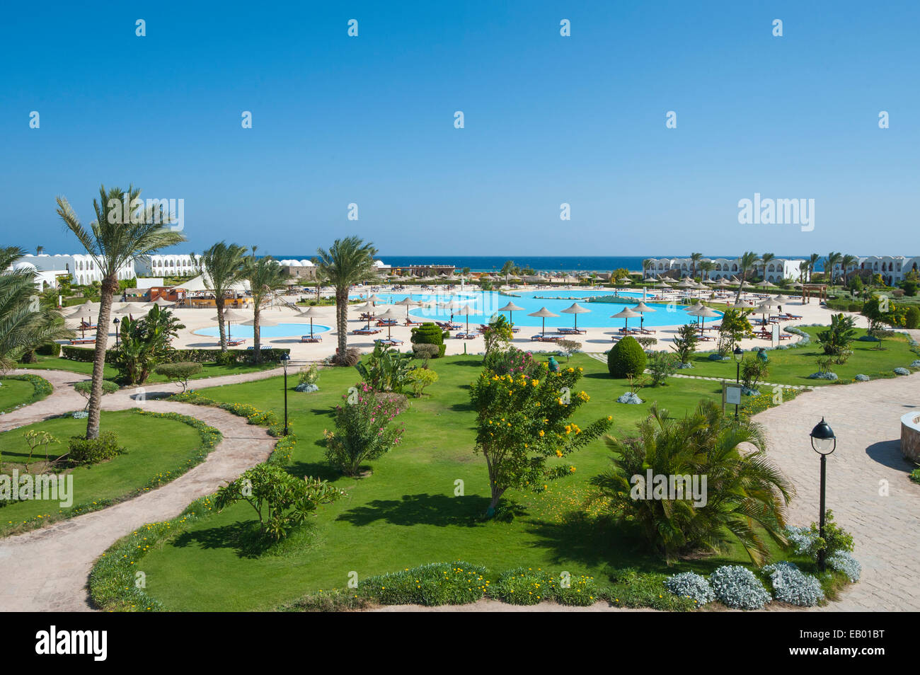 View over a large luxury tropical resort swimming pool with gardens Stock Photo