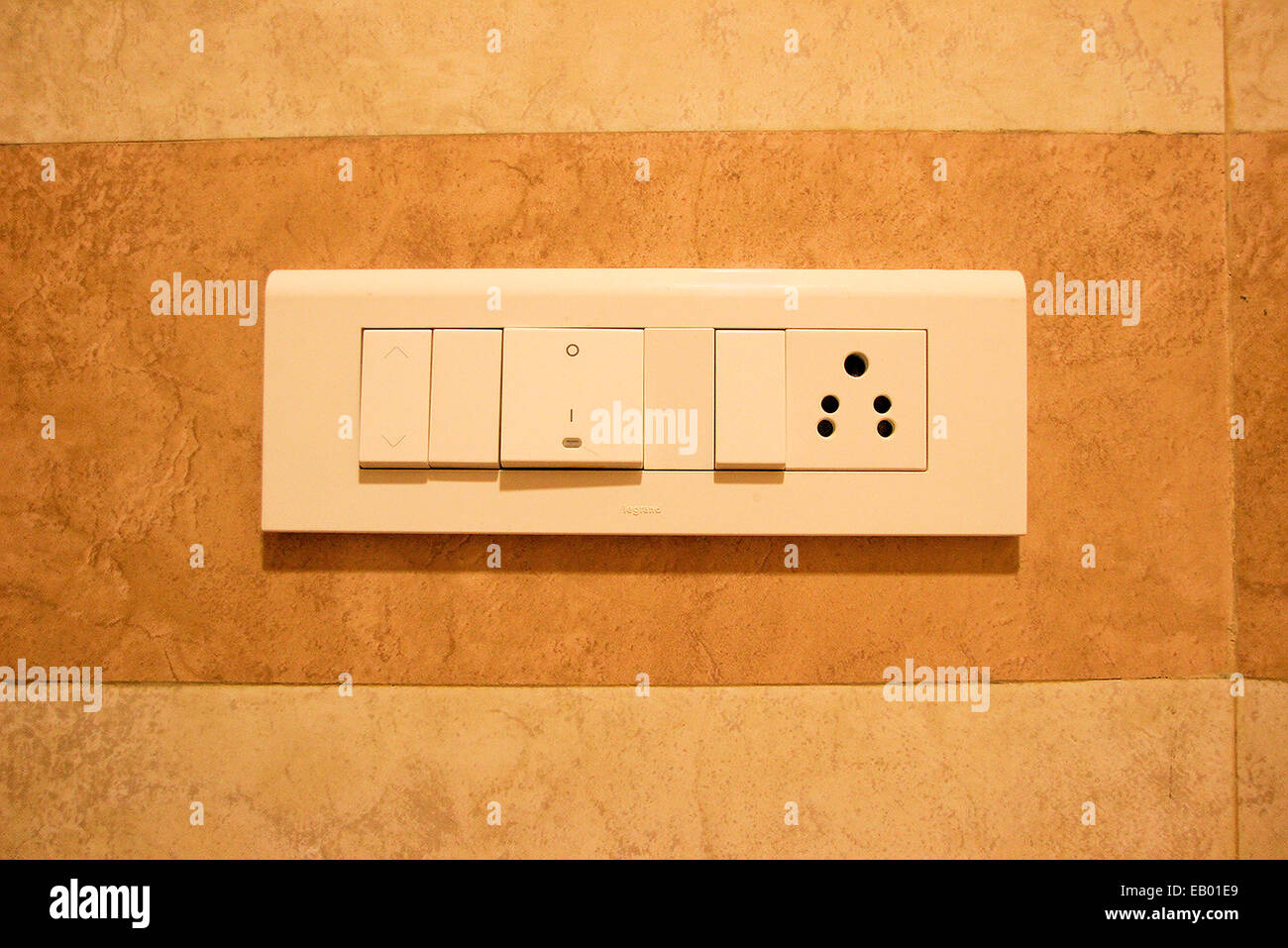 Neat panel of electrical switches and plug points on wall Stock Photo